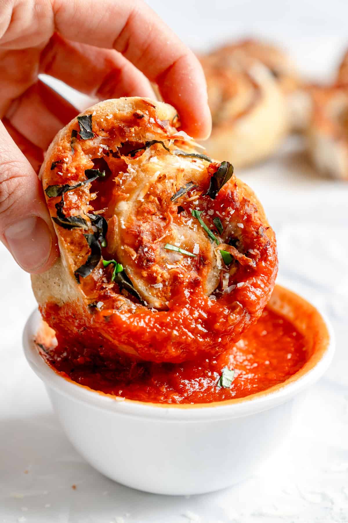 dipping the gluten free pizza rolls in sauce