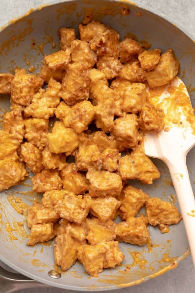 bang bang tofu in a pan on the stove with the sauce