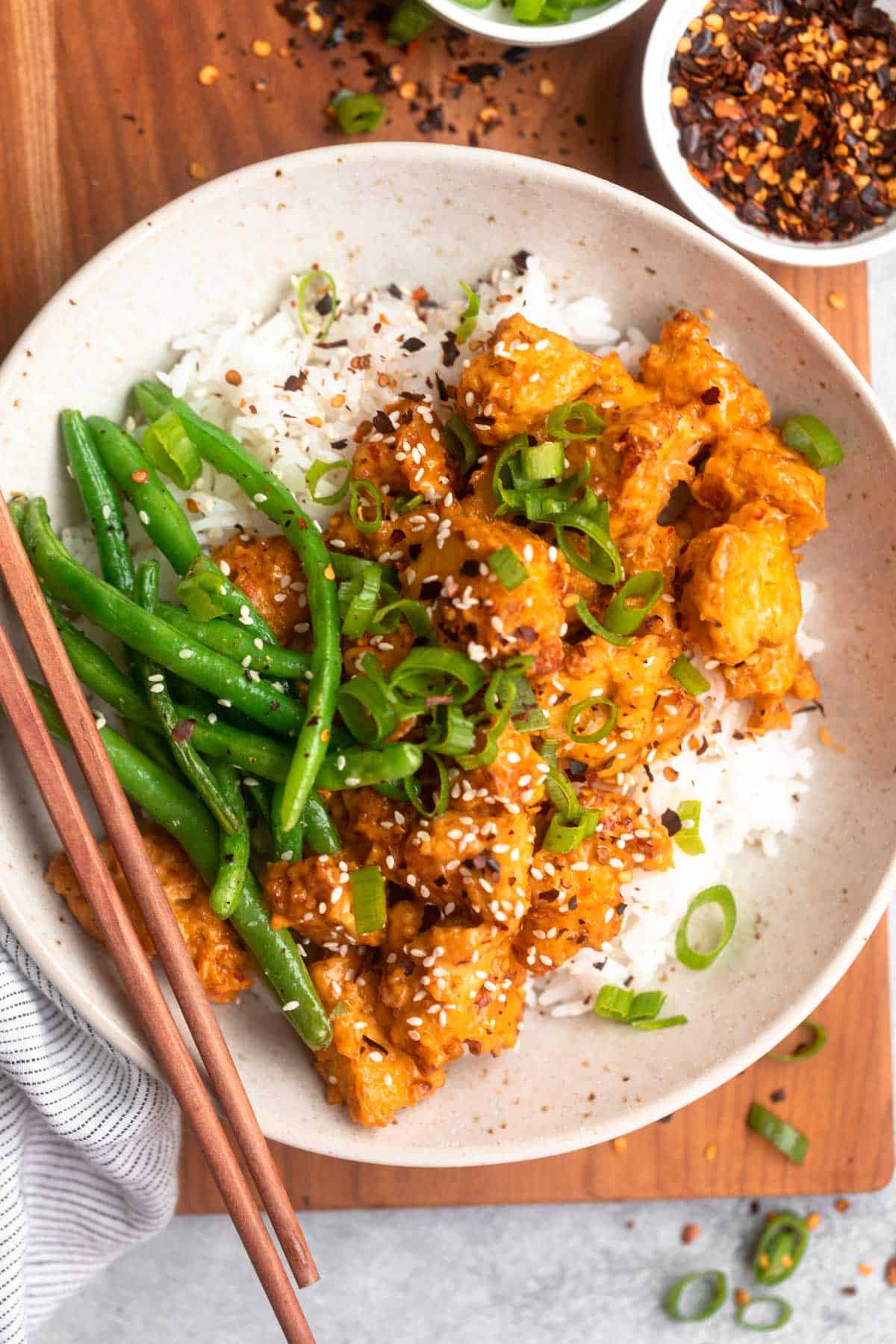 bang bang tofu in a bowl with rice and green beans