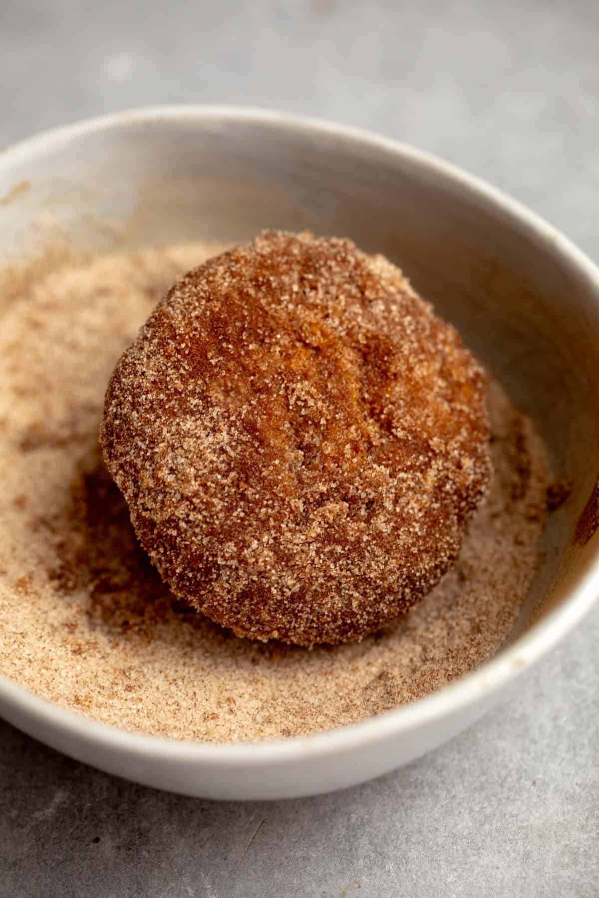 coating the muffin in cinnamon sugar