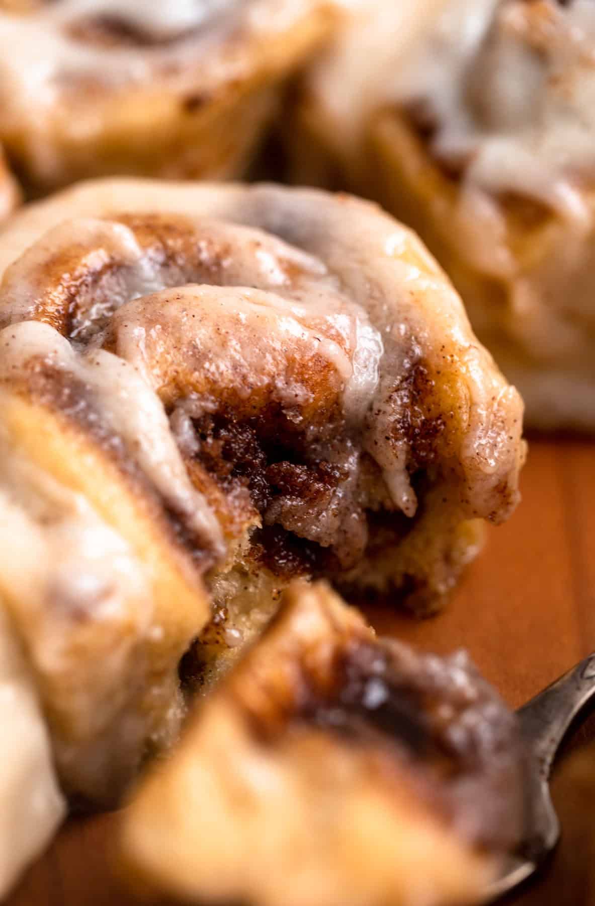 brown butter cinnamon roll with a bite taken out to show texture