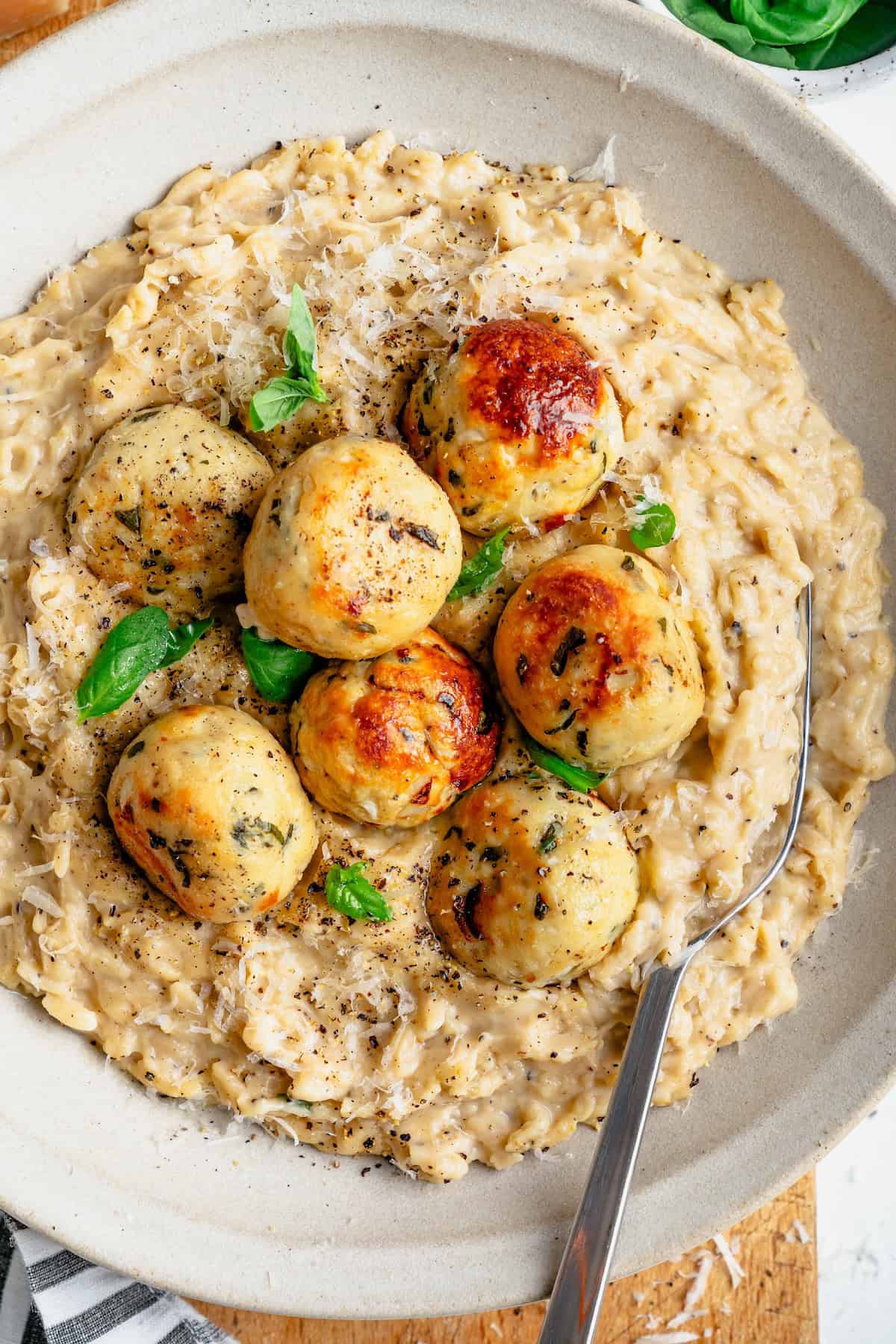 cacio e pepe orzo with chicken meatballs on top