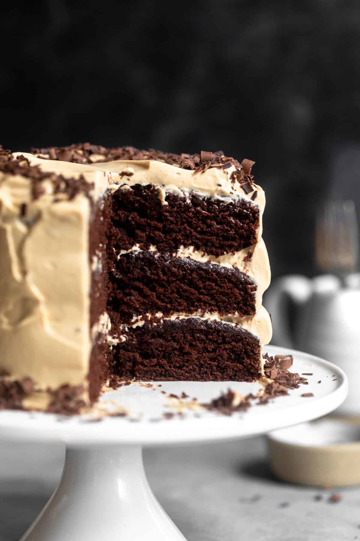 cake with a slice cut out on the cake stand with espresso frosting