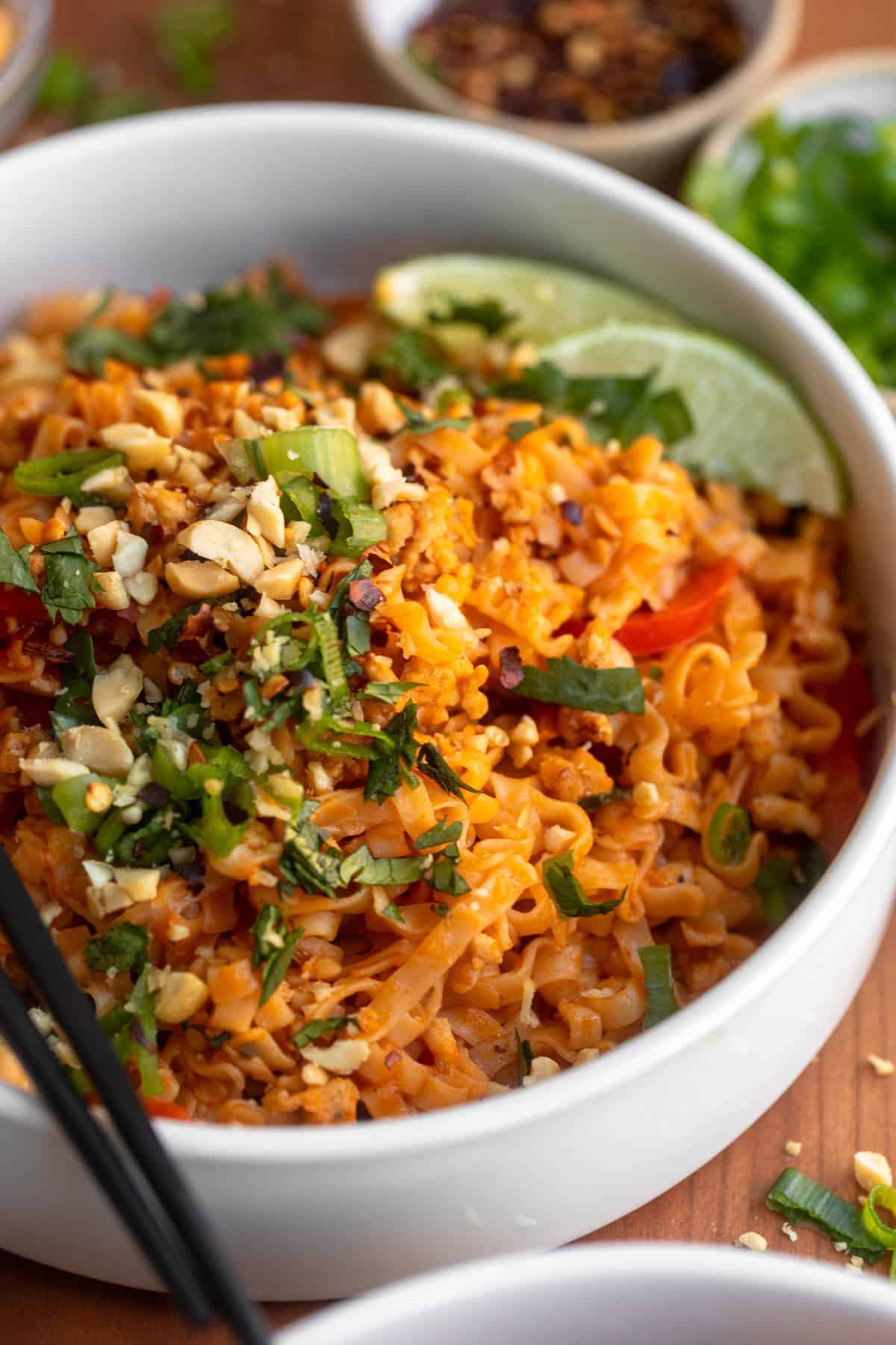 angled view of the curry chicken noodles with peanuts on top