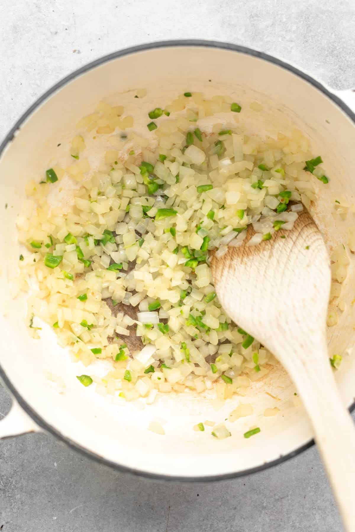sauteeing the white onion in a pot