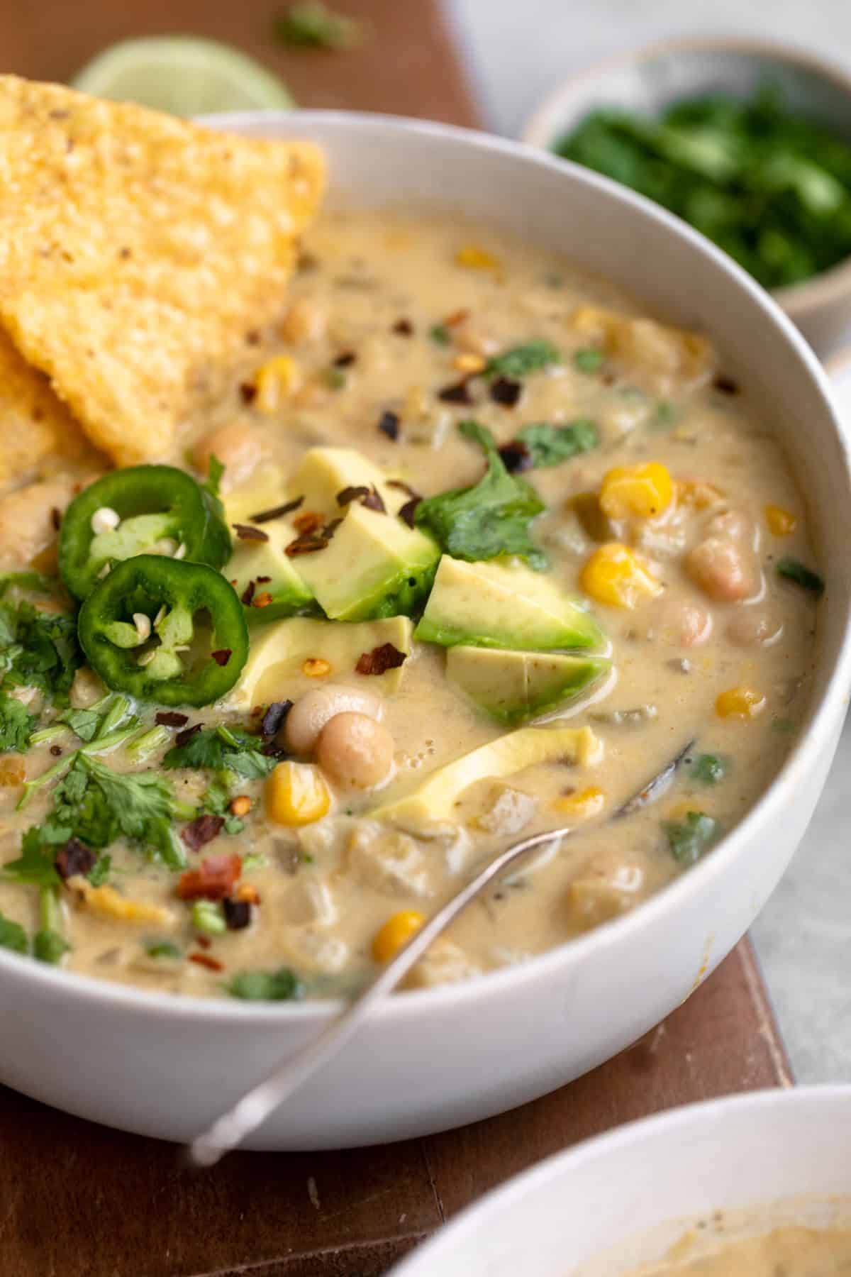 angled view of the white bean chili with a spoon on the side
